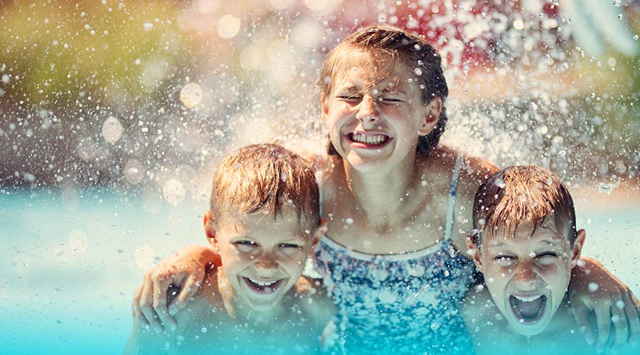 Photo of three kids playing in a swimming pool